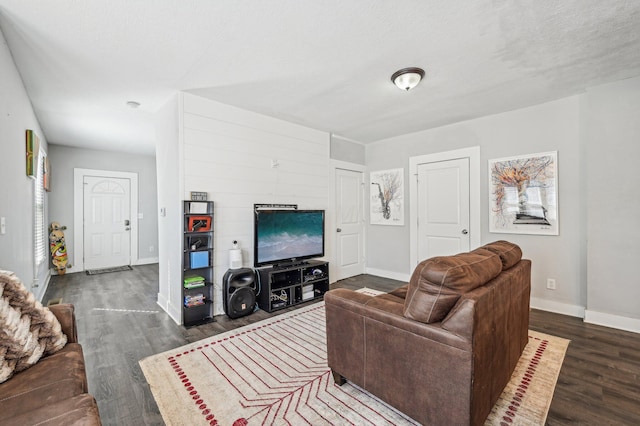 living room with a textured ceiling and dark hardwood / wood-style floors