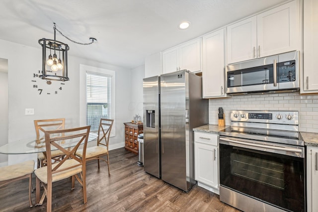 kitchen featuring tasteful backsplash, white cabinetry, stainless steel appliances, and hardwood / wood-style flooring