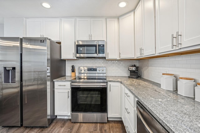 kitchen featuring white cabinetry, tasteful backsplash, light stone counters, dark hardwood / wood-style floors, and appliances with stainless steel finishes