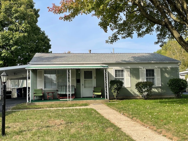 view of front of property with a front lawn, covered porch, and a carport