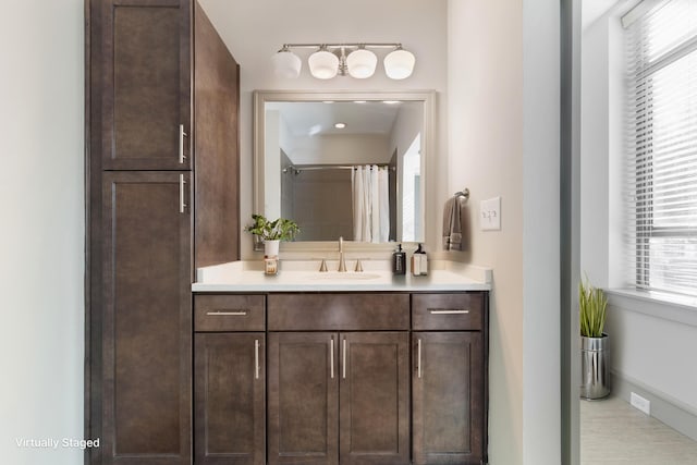 bathroom with a shower with shower curtain, vanity, and a wealth of natural light