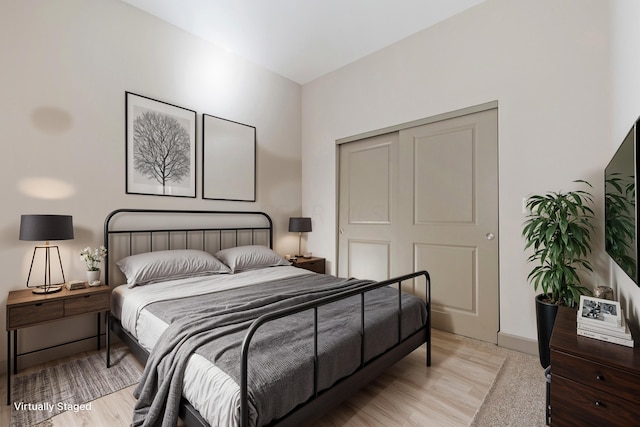 bedroom with light wood-type flooring and a closet