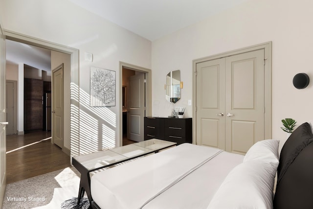 bedroom with a closet and dark wood-type flooring