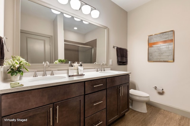 bathroom featuring hardwood / wood-style floors, vanity, toilet, and a shower with door