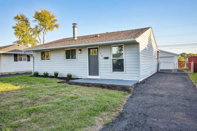 ranch-style home featuring a garage and a front lawn