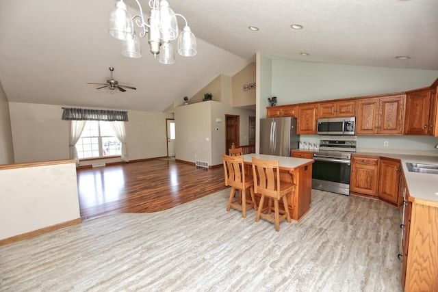 kitchen featuring a center island, light wood-style flooring, visible vents, light countertops, and appliances with stainless steel finishes