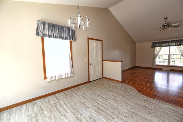 spare room with ceiling fan with notable chandelier, baseboards, wood finished floors, and visible vents