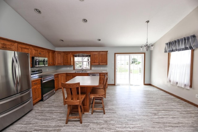 kitchen featuring lofted ceiling, stainless steel appliances, a sink, light wood-style floors, and a chandelier