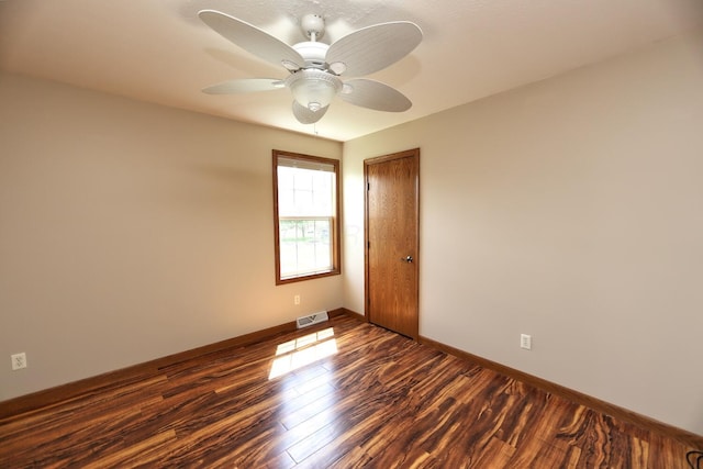 unfurnished room featuring baseboards, visible vents, dark wood-type flooring, and ceiling fan