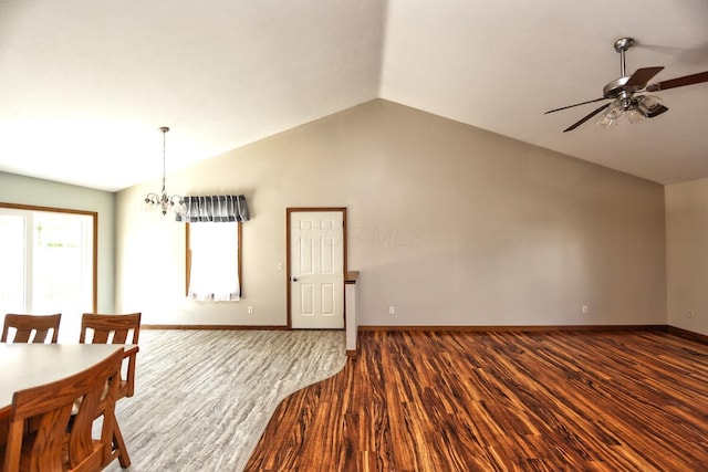 unfurnished dining area with vaulted ceiling, baseboards, dark wood-style flooring, and ceiling fan with notable chandelier