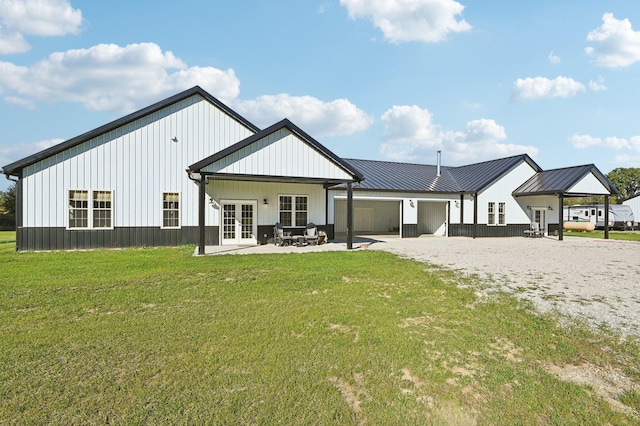 back of property with a yard, a patio area, and french doors