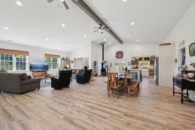 dining room with beam ceiling, ceiling fan, and light hardwood / wood-style floors