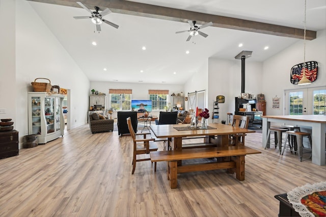 dining space with beam ceiling, ceiling fan, high vaulted ceiling, and light wood-type flooring