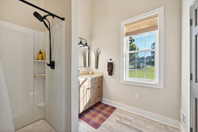 bathroom featuring a shower, vanity, and hardwood / wood-style flooring