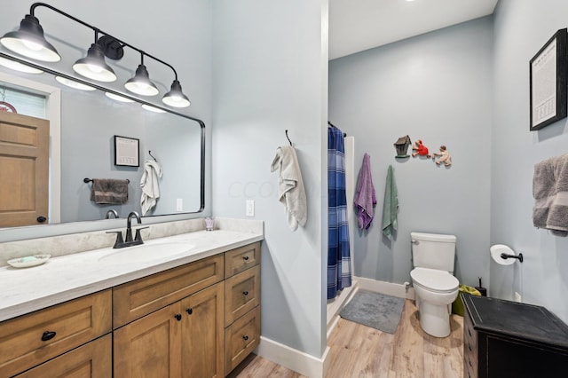 bathroom with a shower with curtain, vanity, wood-type flooring, and toilet