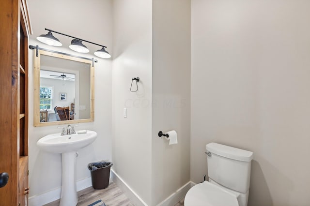 bathroom featuring hardwood / wood-style flooring, ceiling fan, and toilet