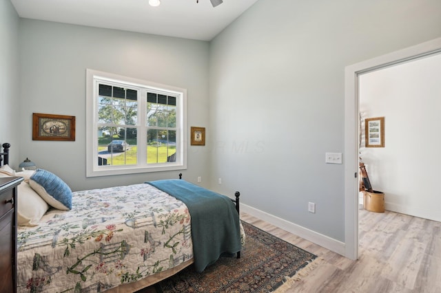 bedroom featuring ceiling fan, light hardwood / wood-style floors, and vaulted ceiling