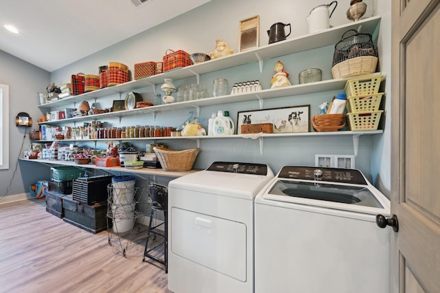 laundry area with washer and dryer and light wood-type flooring