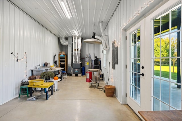 garage featuring french doors, heating unit, and water heater