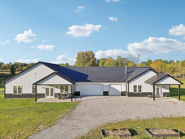 modern inspired farmhouse with a garage, a front yard, and french doors