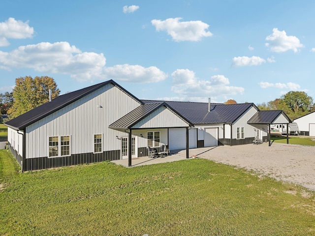 back of house featuring a patio, a garage, and a lawn