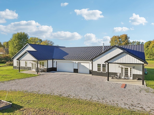 modern inspired farmhouse featuring a patio area, a front yard, and a garage