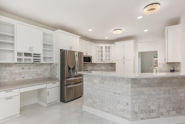 kitchen featuring stainless steel appliances, white cabinetry, tasteful backsplash, and light stone counters