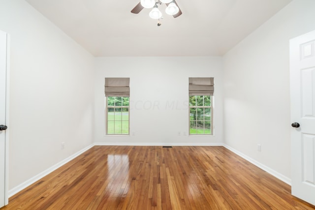 spare room with hardwood / wood-style flooring, ceiling fan, and a healthy amount of sunlight