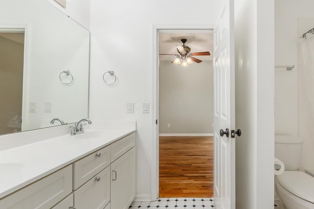 bathroom featuring vanity, hardwood / wood-style flooring, toilet, and ceiling fan