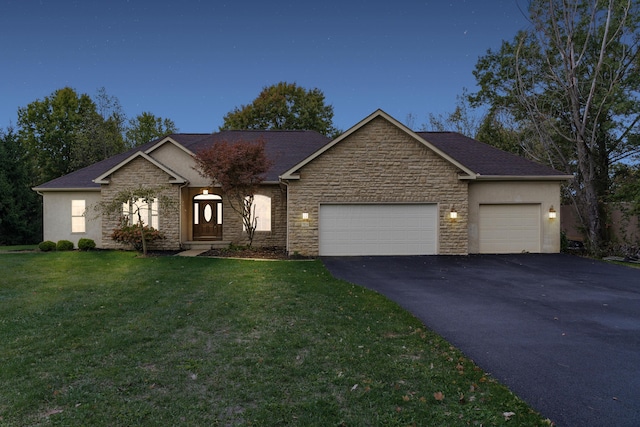 ranch-style home featuring a garage and a lawn