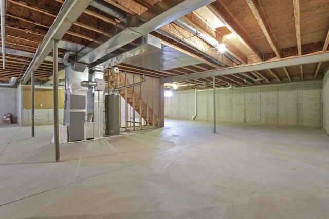 unfinished below grade area featuring heating unit, water heater, and brick wall