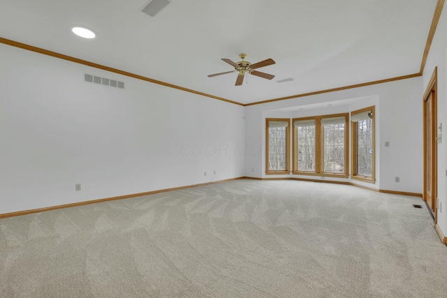 empty room featuring light carpet, visible vents, and crown molding