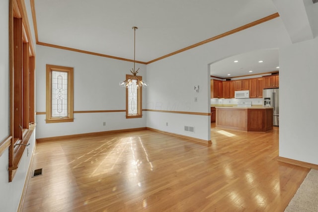 unfurnished living room with light wood-style floors, baseboards, and visible vents