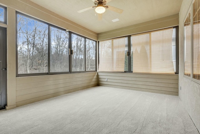 unfurnished sunroom featuring a ceiling fan