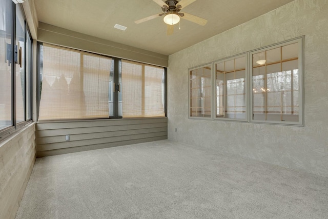 unfurnished sunroom with a ceiling fan