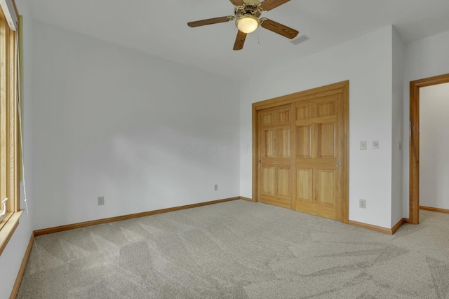 unfurnished bedroom with carpet floors, visible vents, baseboards, and ceiling fan