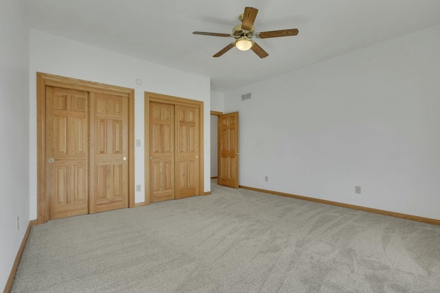 unfurnished bedroom with ceiling fan, carpet, visible vents, and baseboards