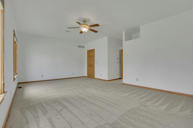 spare room with baseboards, visible vents, a ceiling fan, and light colored carpet