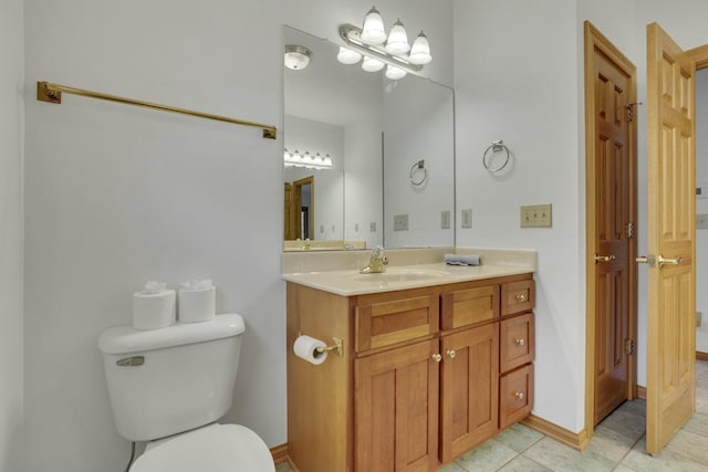 bathroom featuring toilet, tile patterned floors, baseboards, and vanity