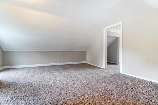 additional living space featuring carpet and lofted ceiling