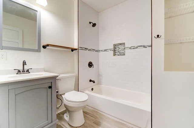 full bathroom with toilet, hardwood / wood-style floors, vanity, and tiled shower / bath