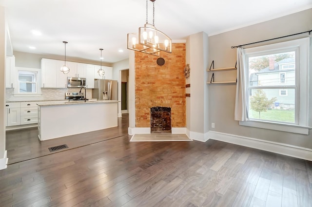 unfurnished living room featuring a chandelier, a large fireplace, and dark wood-type flooring