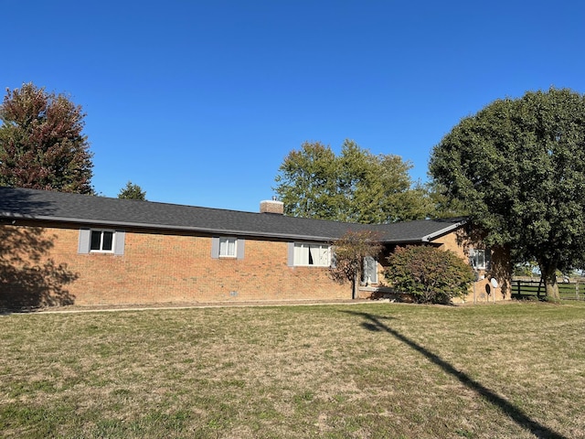 rear view of property with a lawn