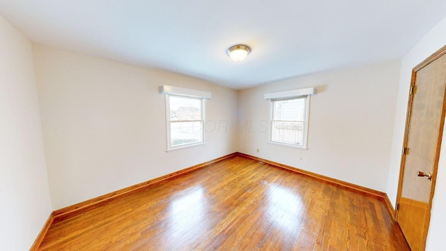 spare room featuring a healthy amount of sunlight and hardwood / wood-style flooring