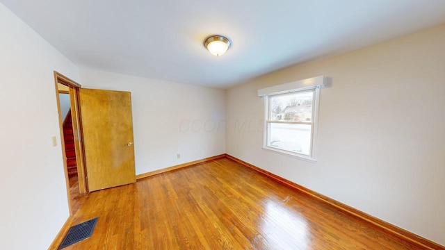 empty room with hardwood / wood-style flooring