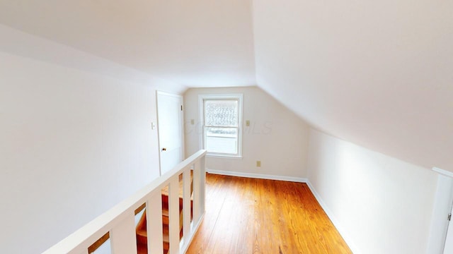 bonus room with hardwood / wood-style flooring and vaulted ceiling