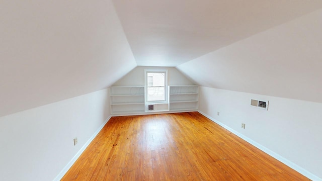 bonus room with vaulted ceiling and light hardwood / wood-style flooring