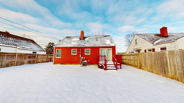 view of snow covered back of property