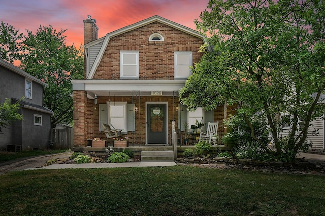 view of front of house with a porch and a yard