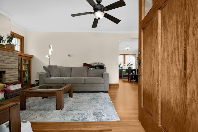 living room featuring crown molding, plenty of natural light, and light hardwood / wood-style flooring